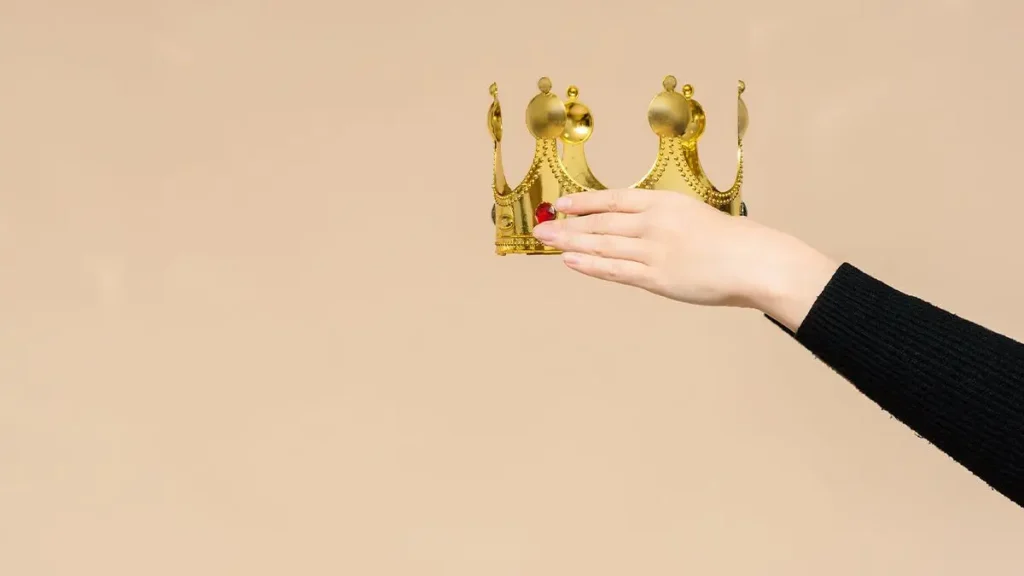 women holding a crown to someone else